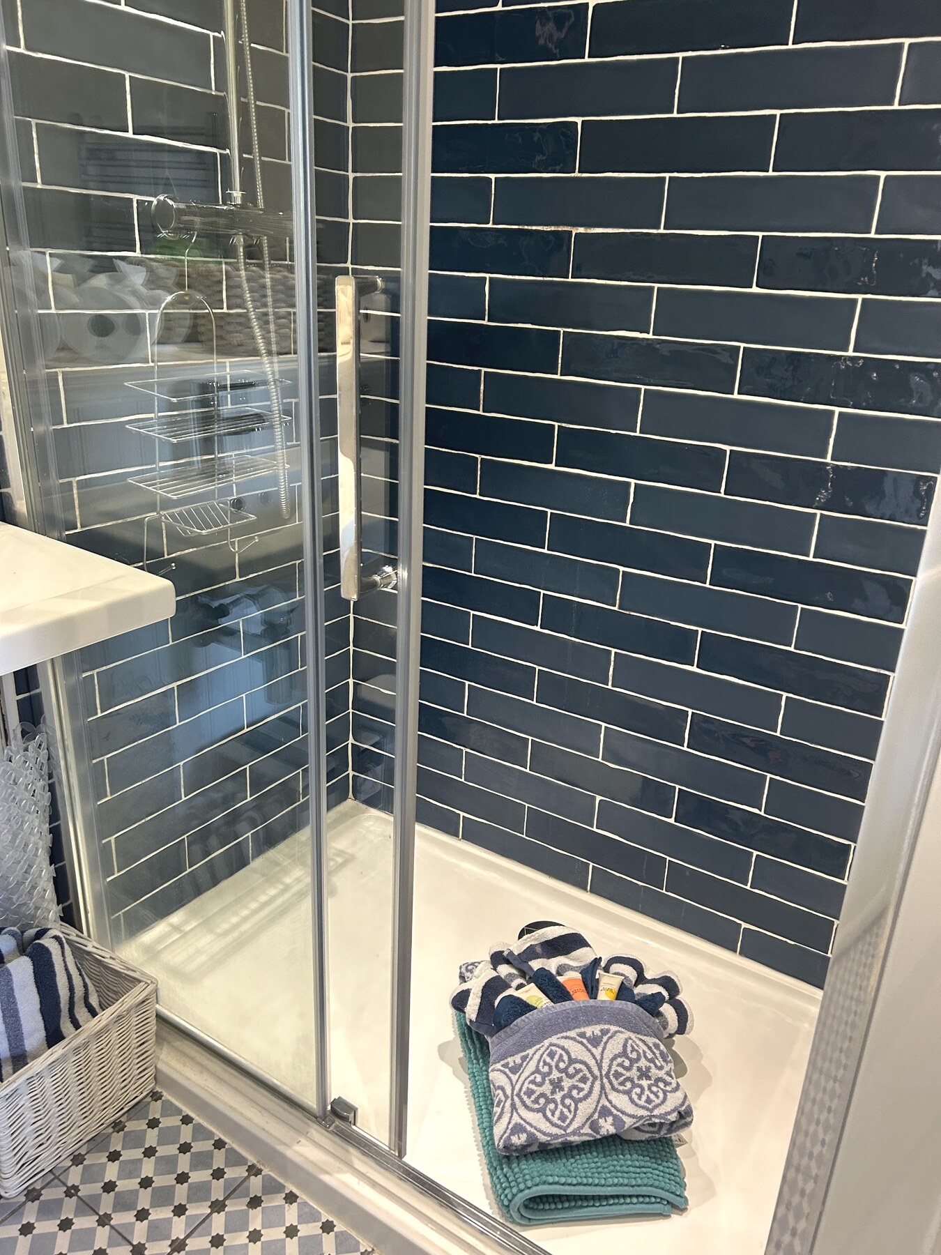 Separate shower room with dark blue tiles